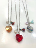 Cadena en Stainless steel con un corazón alambrado a mano acompañado de una perla original de agua dulce.