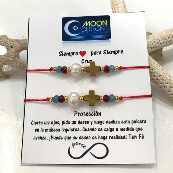 Set de dos pulseras confeccionadas a mano con un charms de cruz en cuarzo hematite, acompañado de una perla original de agua dulce, mini piedras ágatas y montadas en hilo de nylon ajustable. 